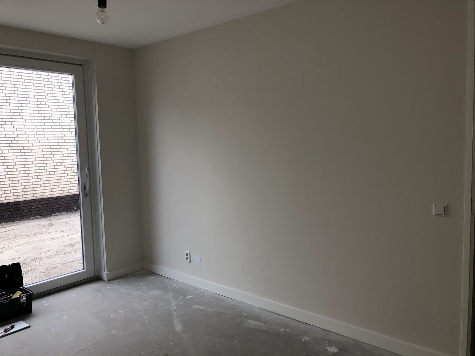Lege kamer met net geschilderde lichte wanden en een openslaande deur